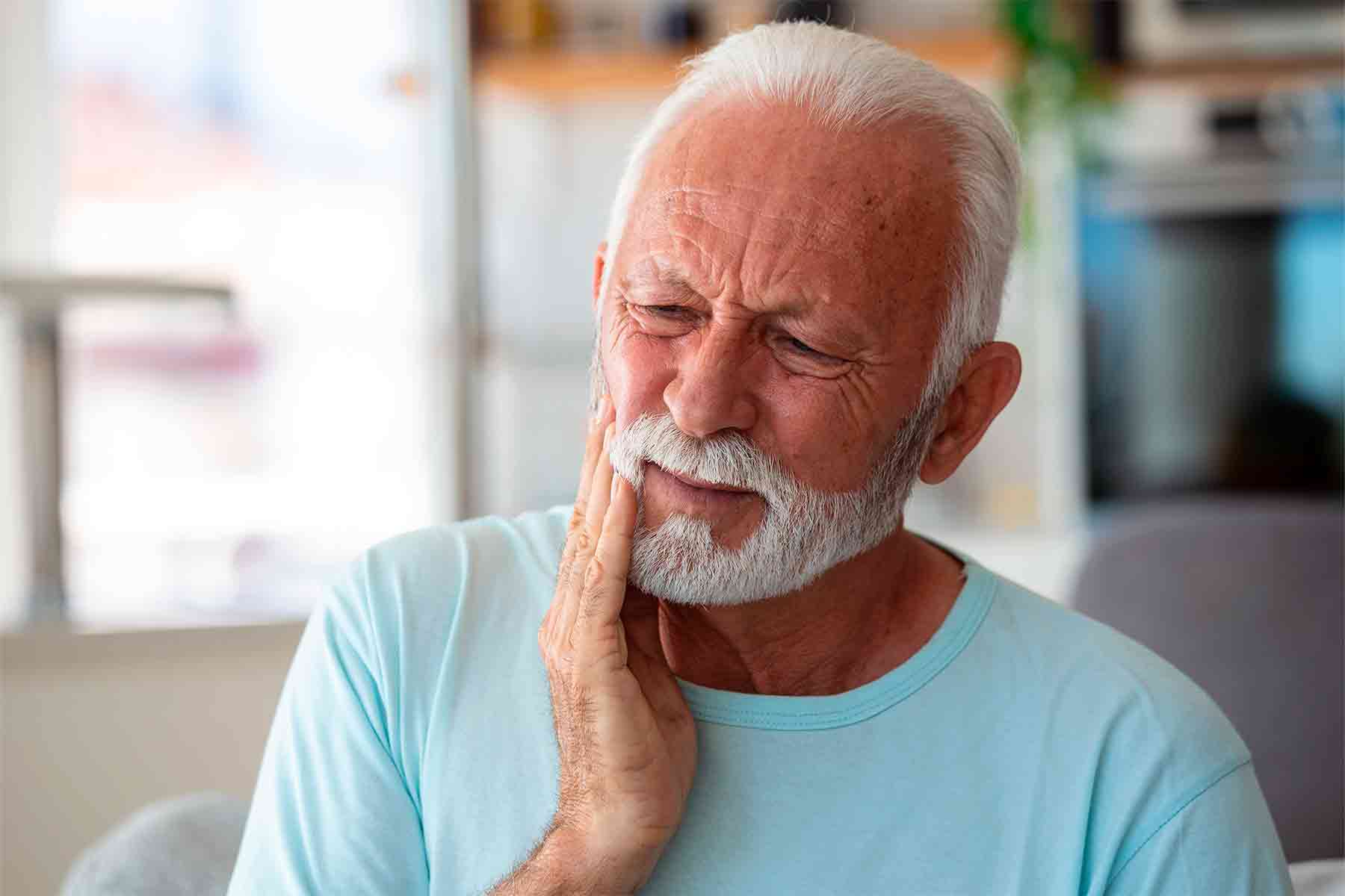 Hombre mayor con dolor en los implantes dentales