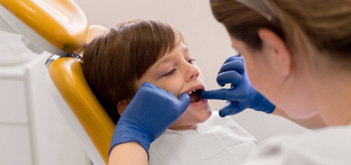 odontopediatra revisando lesiones traumáticas en la boca de un niño